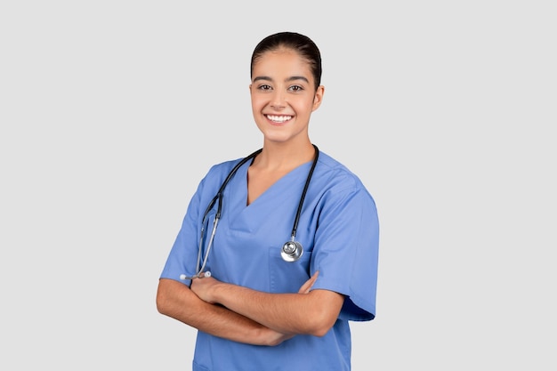 Una doctora radiante con una cálida sonrisa vestida con una bata azul y un estetoscopio