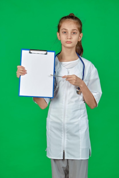 Una doctora se para sobre un fondo verde con una carpeta en las manos