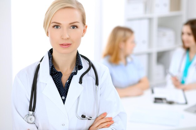 Doctora sonriendo en el fondo con el paciente.