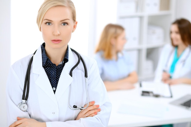 Doctora sonriendo en el fondo con el paciente.