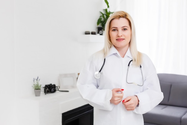 Doctora sonriente en bata blanca, sobre blanco