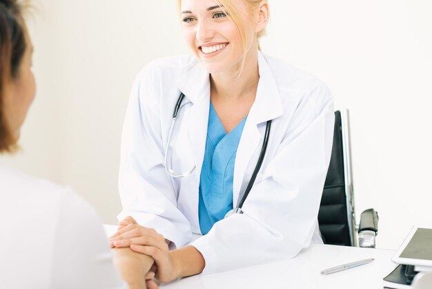 Foto una doctora sonriente consolando a un paciente en una clínica médica