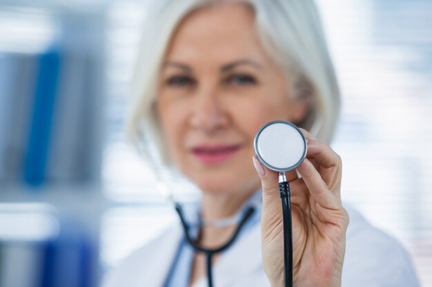 Doctora sonriente mostrando estetoscopio