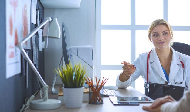 Doctora sosteniendo el formulario de solicitud mientras consulta al paciente