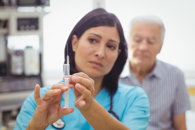 Doctora sosteniendo una inyección