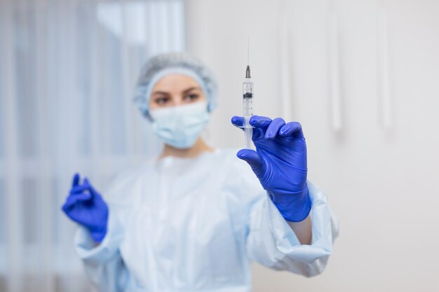 Doctora sosteniendo una jeringa con inyección