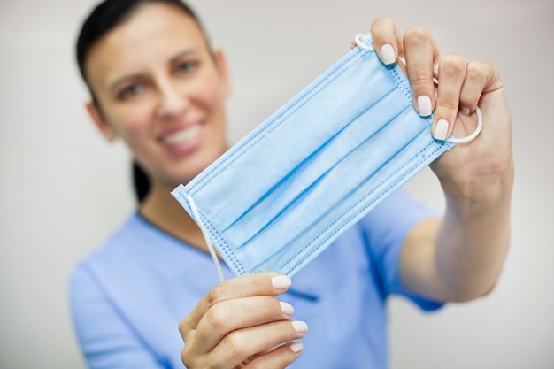 Doctora sosteniendo una máscara médica