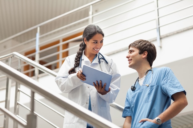 Doctora sosteniendo una tableta en las escaleras