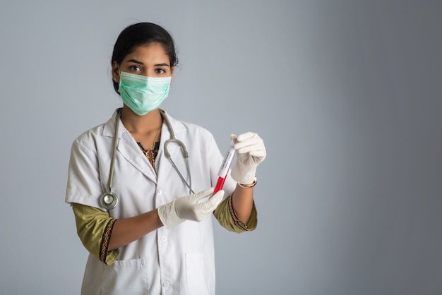 Doctora sosteniendo un tubo de ensayo con muestra de sangre para coronavirus o análisis 2019-nCoV.