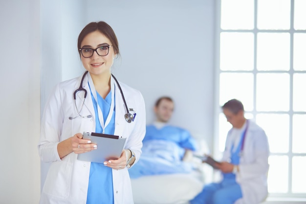 Doctora con tablet PC en el vestíbulo del hospital