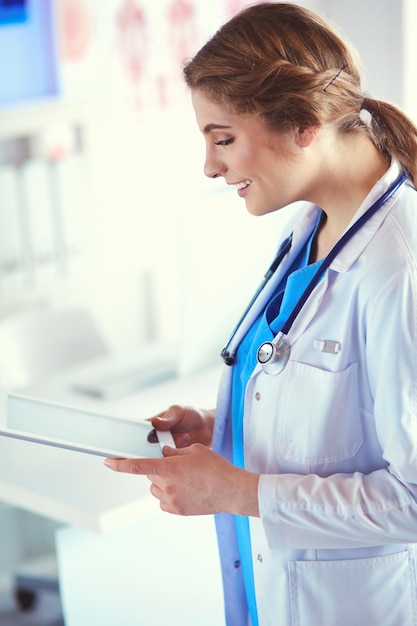 Doctora con tablet PC en el vestíbulo del hospital