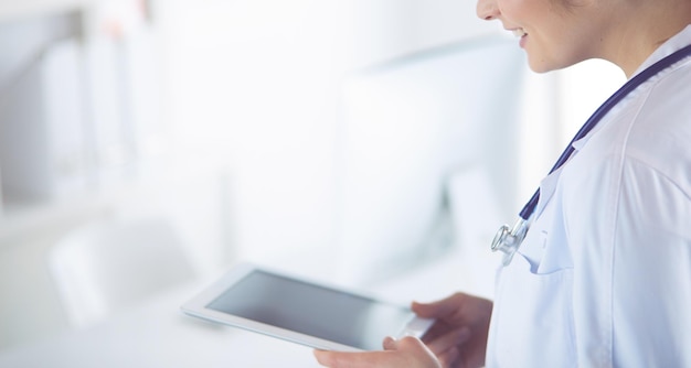 Doctora con tablet PC en el vestíbulo del hospital