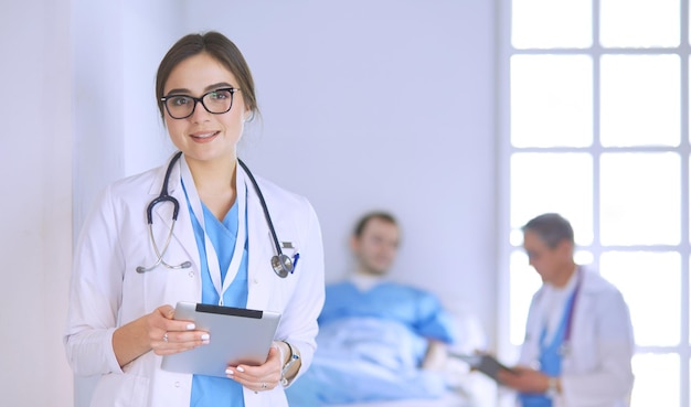 Doctora con tablet PC en el vestíbulo del hospital