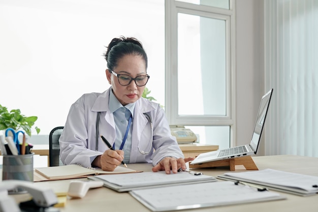 Doctora trabajando con documentos en la oficina