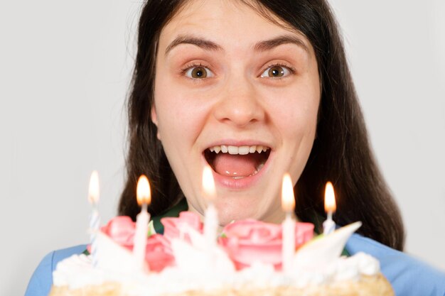 Una doctora con uniforme azul sostiene un pastel de cumpleaños