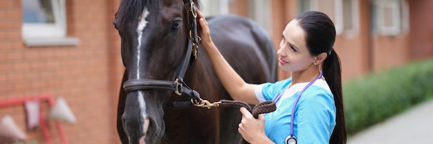 Doctora en uniforme con caballo en establo