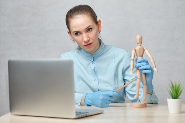 Doctora en uniforme con una figura de madera