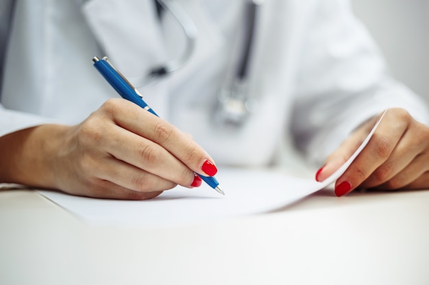 Foto doctora en uniforme en su escritorio