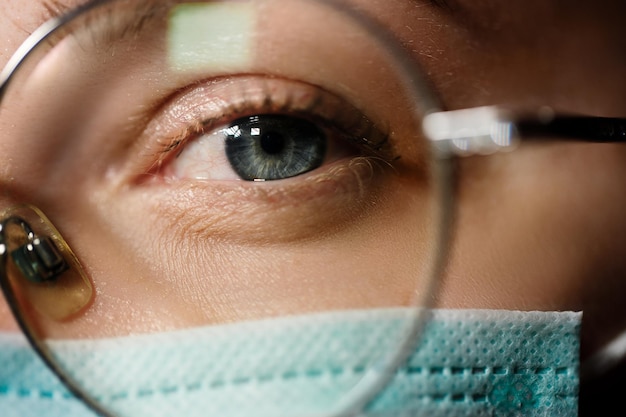 Foto la doctora usa una máscara médica y te mira a través de las gafas.