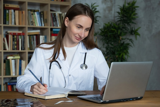 Doctora usando su computadora portátil en el consultorio médico