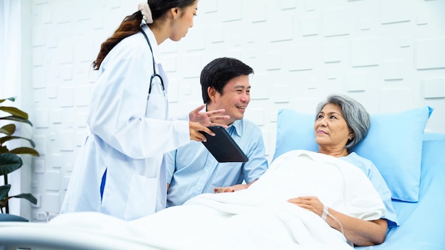 Foto la doctora está usando una tableta para registrar los resultados de una paciente anciana