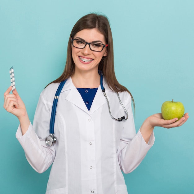 Doctora en vasos con manzana y pastillas