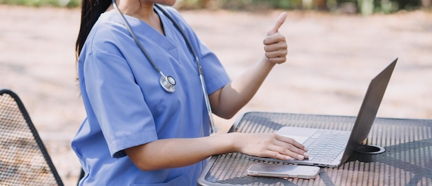 Doctora vistiendo matorrales en el pasillo del hospital mediante tableta digital