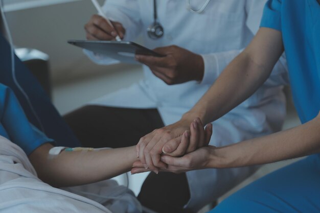 Las doctoras asiáticas toman la mano del paciente y alientan y brindan asesoramiento médico mientras controlan la salud del paciente en la cama Concepto de atención y compasión atención prenatal Amenaza de aborto