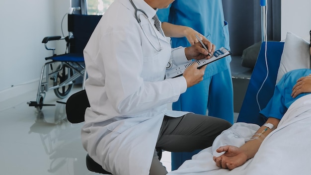 Las doctoras asiáticas toman la mano del paciente y alientan y brindan asesoramiento médico mientras controlan la salud del paciente en la cama Concepto de atención y compasión atención prenatal Amenaza de aborto