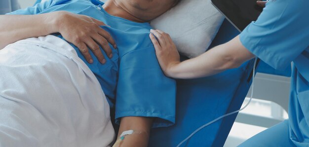 Las doctoras asiáticas toman la mano del paciente y alientan y brindan asesoramiento médico mientras revisan la salud del paciente en la cama Concepto de atención y atención prenatal compasiva Amenaza de aborto