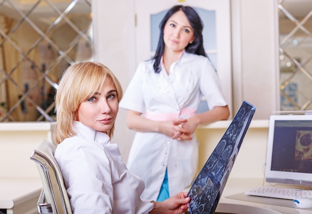 Doctoras mirando una radiografía de tomografía