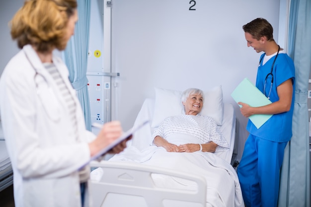 Doctores hablando con un paciente mayor