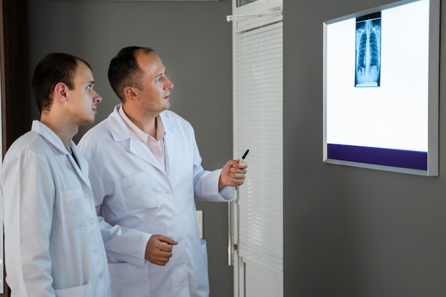 Los doctores mirando los resultados de una radiografía en el hospital Discutiendo temas médicos