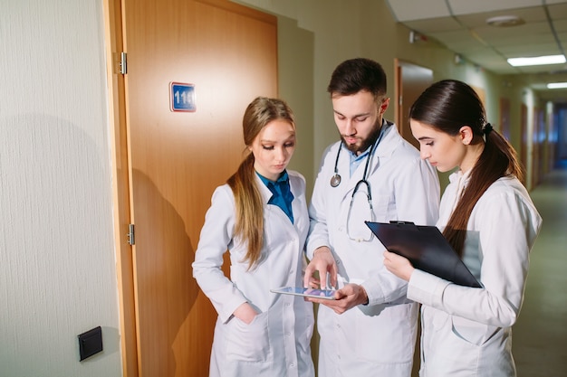 Doctores que discuten el cardiograma del paciente en la tableta.