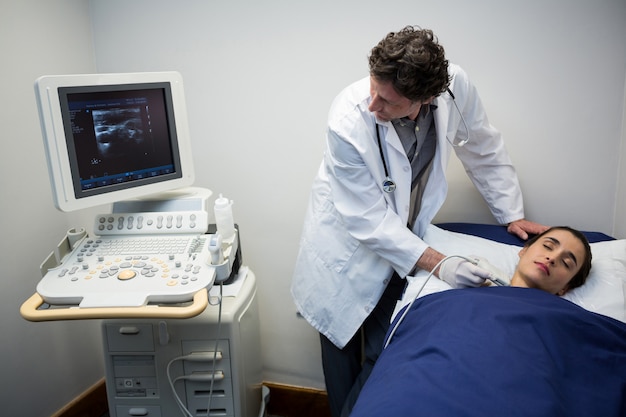 Doctores realizando una ecografía Doppler en el cuello del paciente