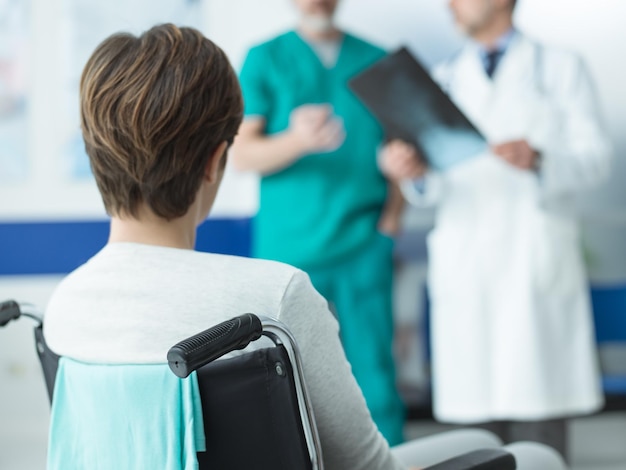 Doctores revisando la radiografía de un paciente discapacitado