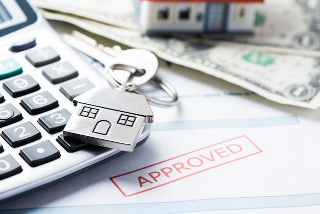 Documento de empréstimo aprovado para hipoteca com chaves da casa