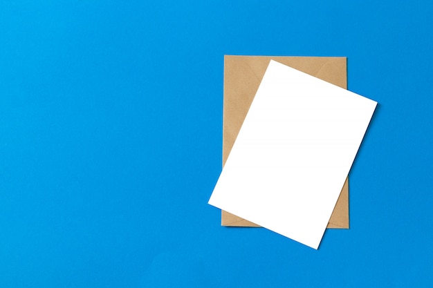 Documento de envelope Kraft marrom maquete com cartão branco em branco isolado em fundo azul