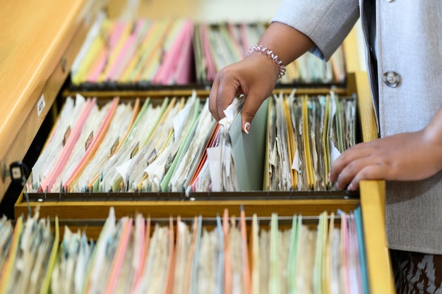 Documentos de búsqueda de mujeres profesionales en el archivador de la oficina.