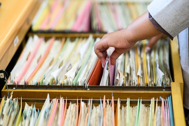 Documentos de búsqueda de mujeres profesionales en el archivador de la oficina.