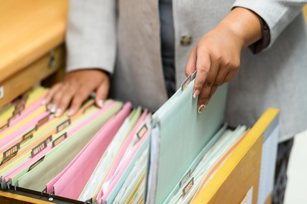 Documentos de búsqueda de mujeres profesionales en el archivador de la oficina.