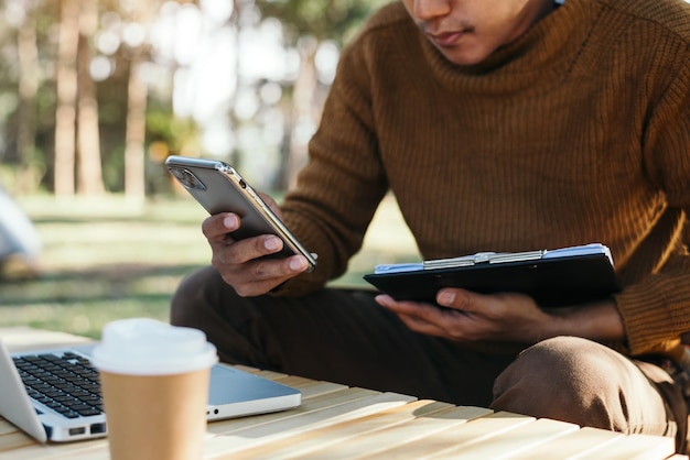 Documentos de negócios na mesa de escritório com smartphone e gráfico financeiro ao ar livre