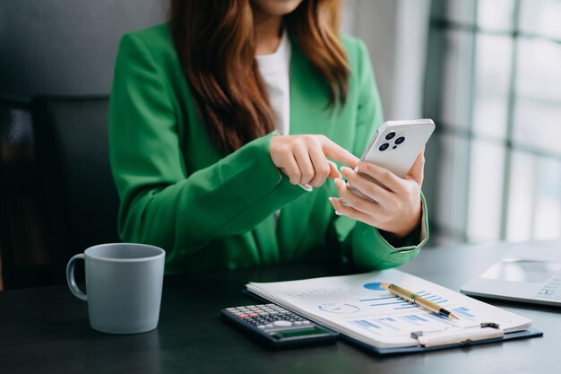 Foto documentos de negócios na mesa do escritório com telefone inteligente e tablet digital e gráfico financeiro e mulher trabalhando