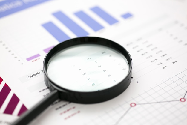 Documentos de estadísticas financieras con lentes en la mesa de la oficina