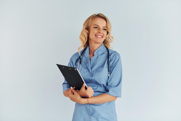 Documentos de retención Joven doctora en uniforme está en el interior