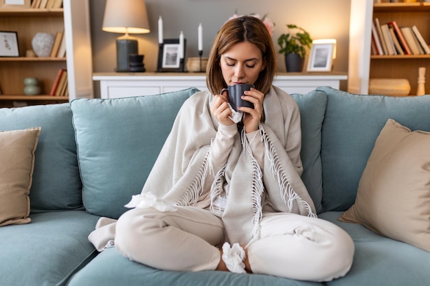 Foto doença conceito de problema de vírus sazonal mulher estar doente com gripe bebendo chá no sofá mulher doente deitada na cama com febre alta gripe fria e enxaqueca