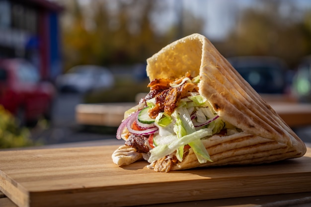 Döner kebab an einem lokalen straßenlebensmittelstand auf hölzernem schneidebrett