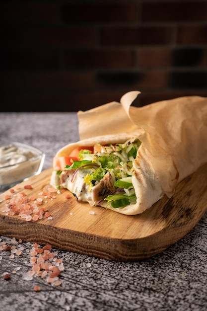 Döner Kebab ein Schawarma in einer Grube aus frischem Gemüse und Fleisch mit großem Gewürzrestaurant, das auf...