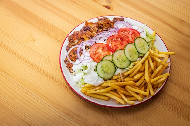 Foto döner kebab oder gyros auf einem teller mit pommes frites