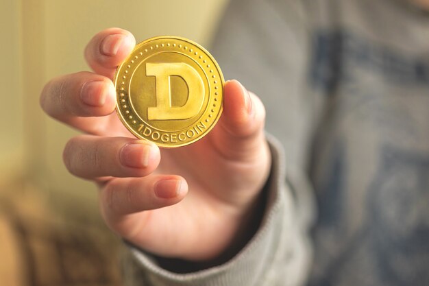 Dogecoin-Kryptowährung in der Hand Nahaufnahme Geschäftshintergrundfoto